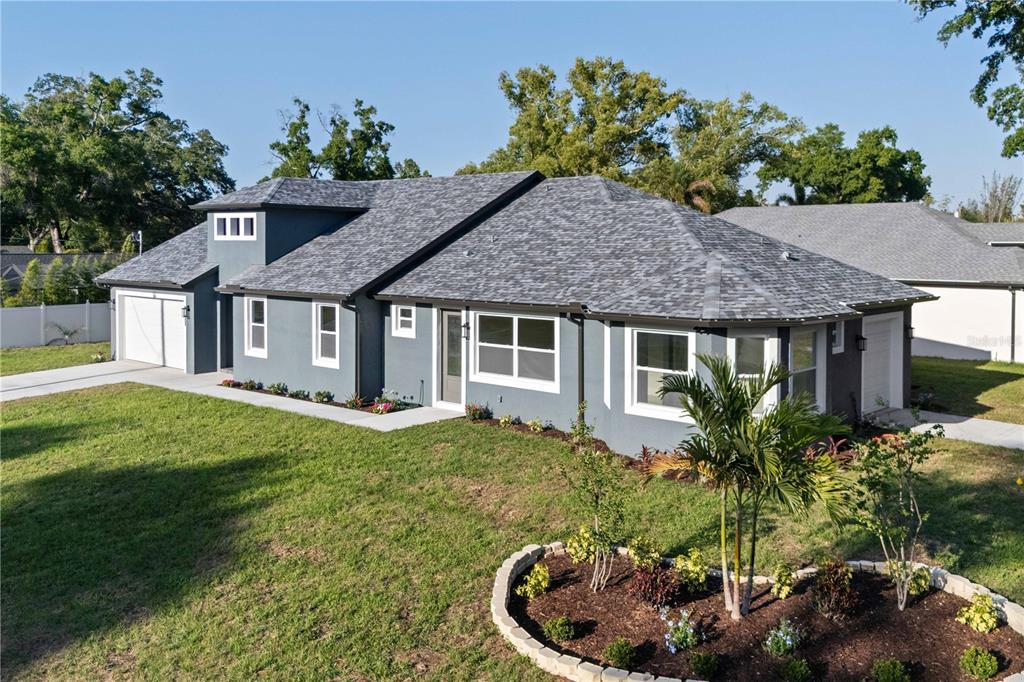 A gray, single-story house with a shingled roof and a landscaped front yard — 6401 FELICE AVENUE, TAMPA, FL