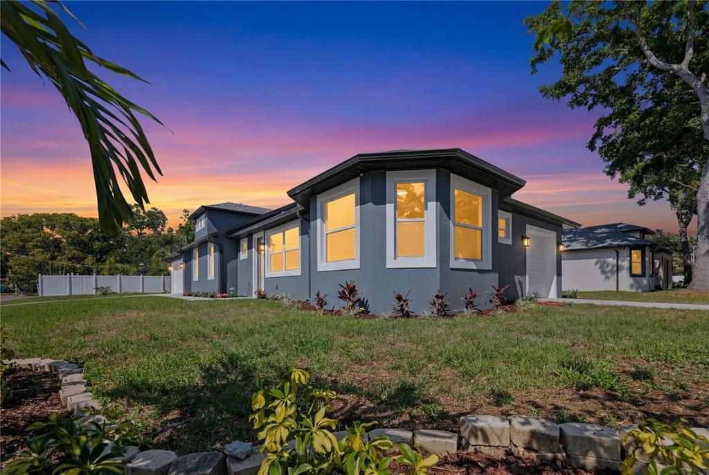 A gray single-story house with a bay window exterior and a sunset sky background — 6401 FELICE AVENUE, TAMPA, FL