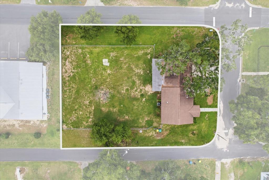 An aerial view shows a house on a corner lot with a large grassy yard — 310 N CITRUS AVENUE, INVERNESS, FL