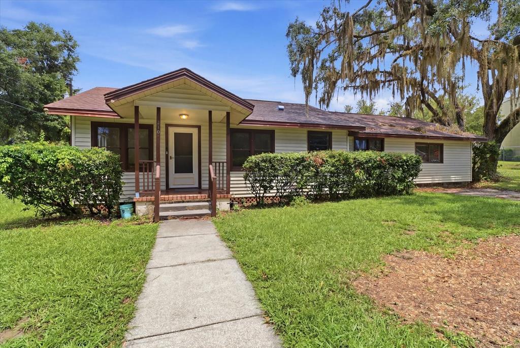 A single-story house with light siding, a covered front porch, and a concrete walkway — 310 N CITRUS AVENUE, INVERNESS, FL