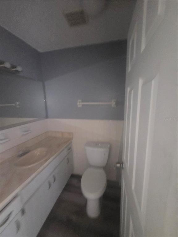 A bathroom features a vanity with a sink, a toilet, and gray walls — 1316 MARKHAM AVENUE UNIT B, SPRING HILL, FL