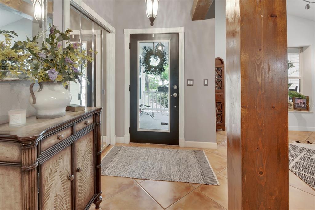 A living room with a fireplace and wood beam opens into a tiled entryway — 1820 DAVIS AVENUE, DELAND, FL