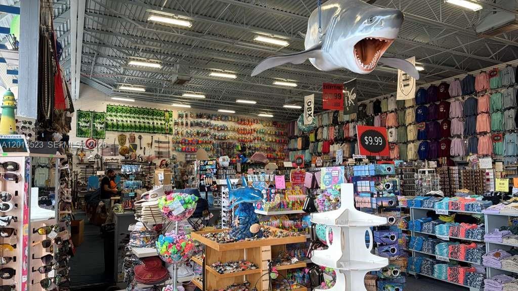 A retail store interior features a large hanging shark model and shelves of souvenir merchandise — 40194 Tuna Ter, NC 27915, NC