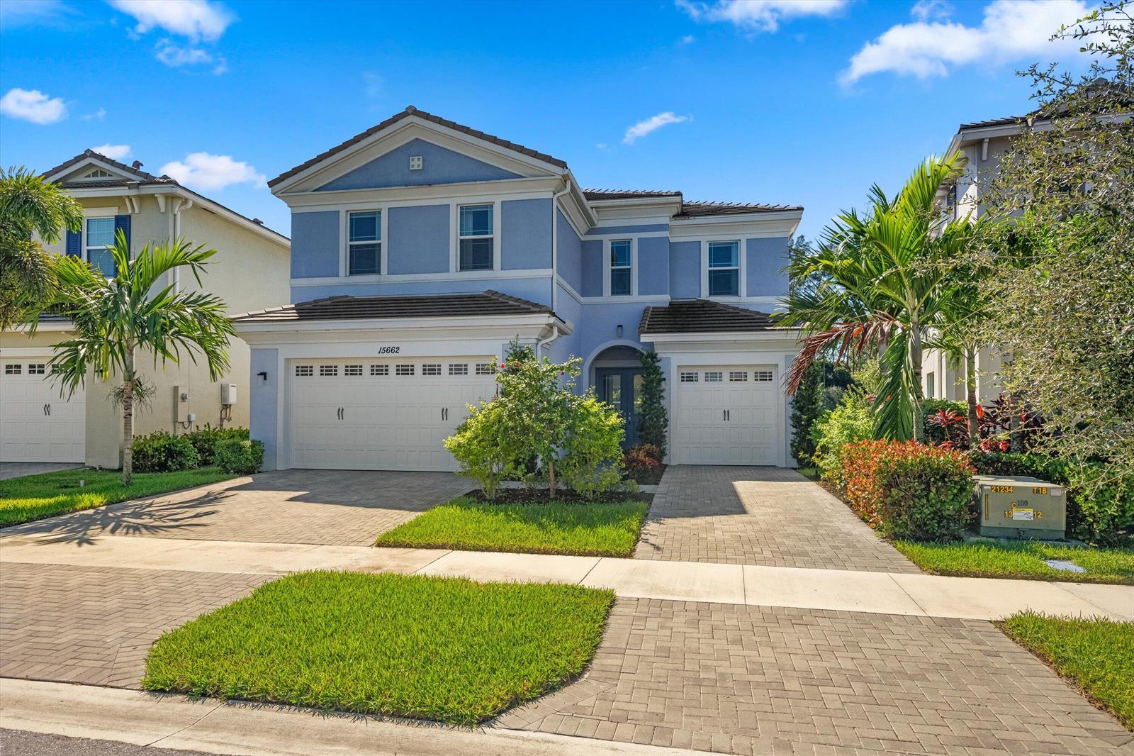 A two-story blue house with a three-car garage and a paved driveway — 15662 Orchard Drive, Westlake FL 33470, WESTLAKE, FL