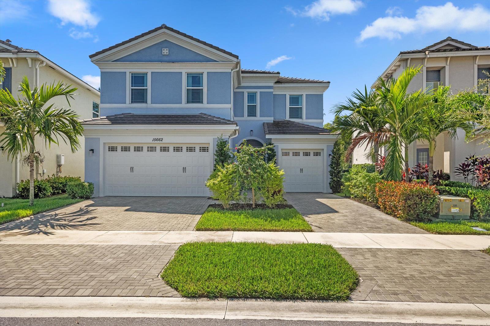 A two-story blue house with a three-car garage and a paved driveway — 15662 Orchard Drive, Westlake FL 33470, WESTLAKE, FL