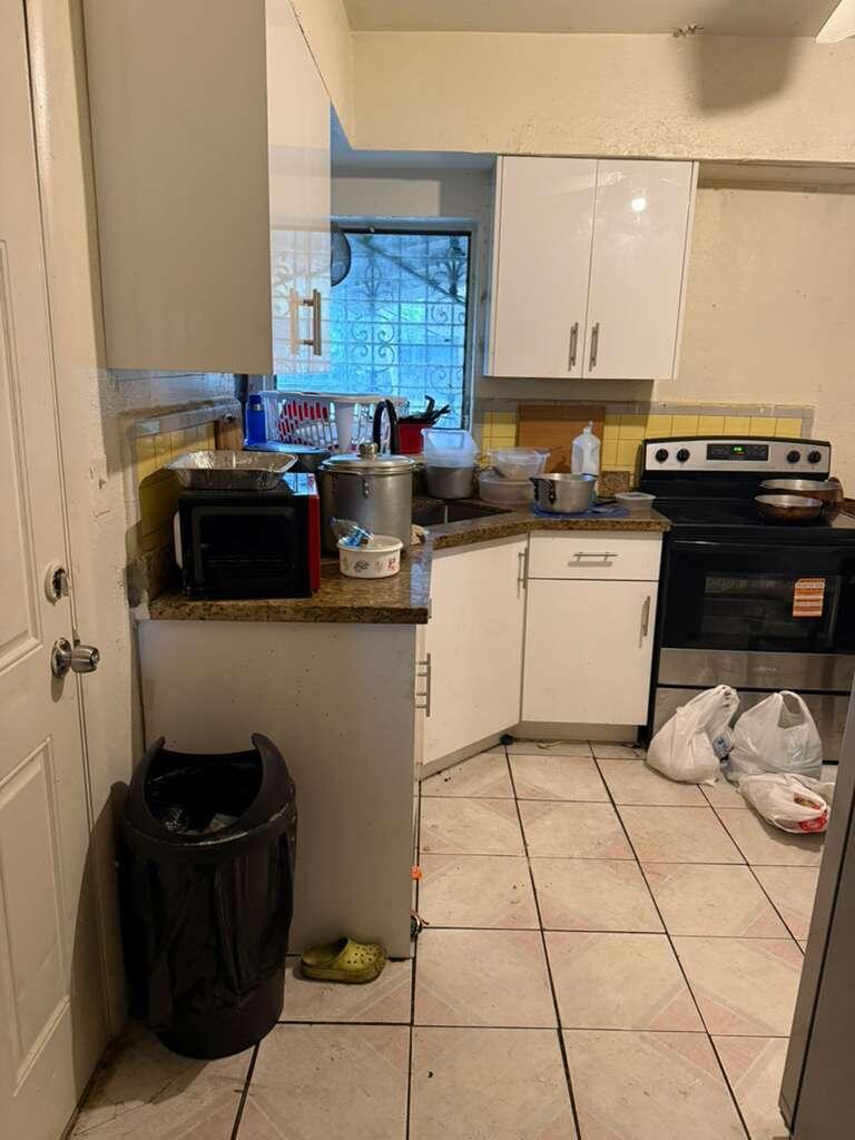 A kitchen with white cabinets, granite countertops, a stainless steel stove, and tiled flooring — 139 NE 63rd Street, Miami FL 33138, MIAMI, FL