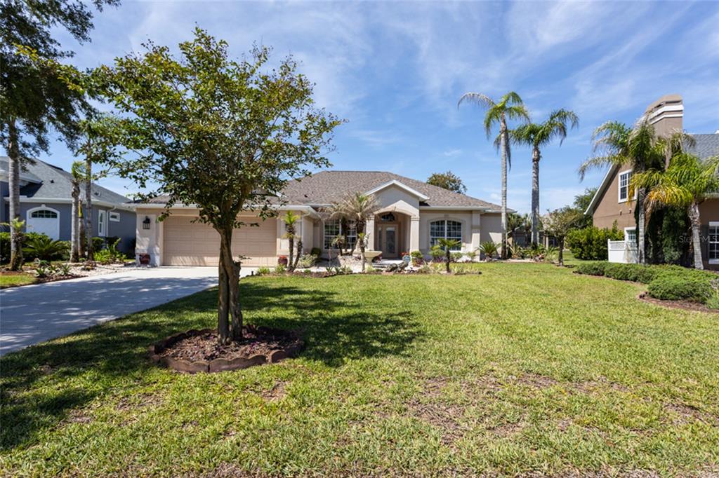 A single-story house with a beige exterior, a two-car garage, and a concrete driveway — 6 S LAKEWALK DRIVE, PALM COAST, FL