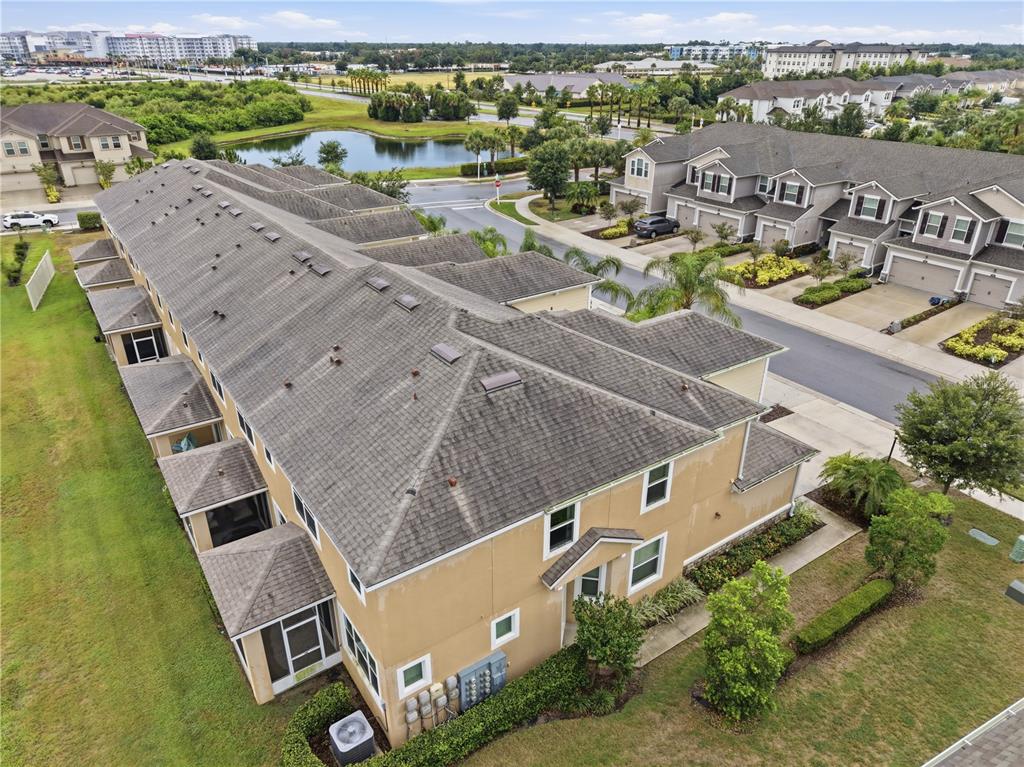 An aerial view shows a multi-unit townhouse building with a tan exterior and gray roof — 5553 PLEASANTVIEW COURT, BRADENTON, FL
