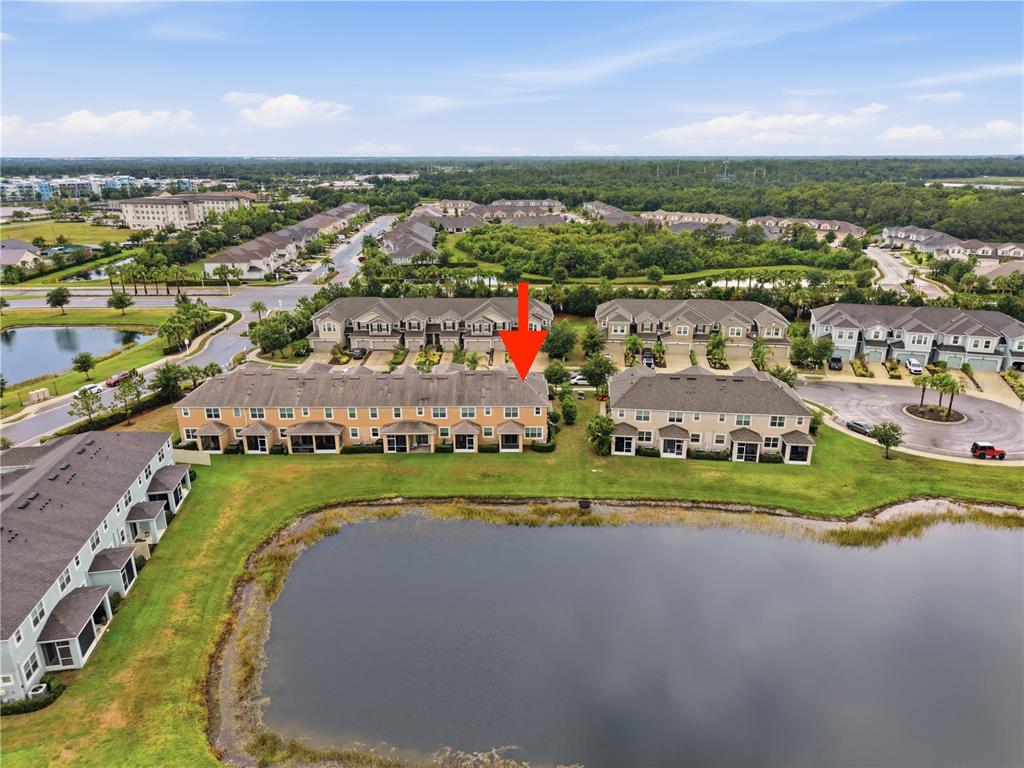 An aerial view shows a multi-unit townhouse building with a red arrow pointing to a unit — 5553 PLEASANTVIEW COURT, BRADENTON, FL
