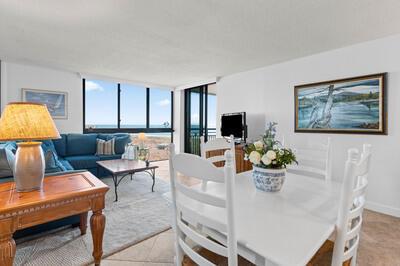 A bright living and dining area features a blue sectional sofa and white dining set — FORT PIERCE, FL