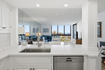 A kitchen island with a stainless steel sink overlooks a living area with ocean views — FORT PIERCE, FL