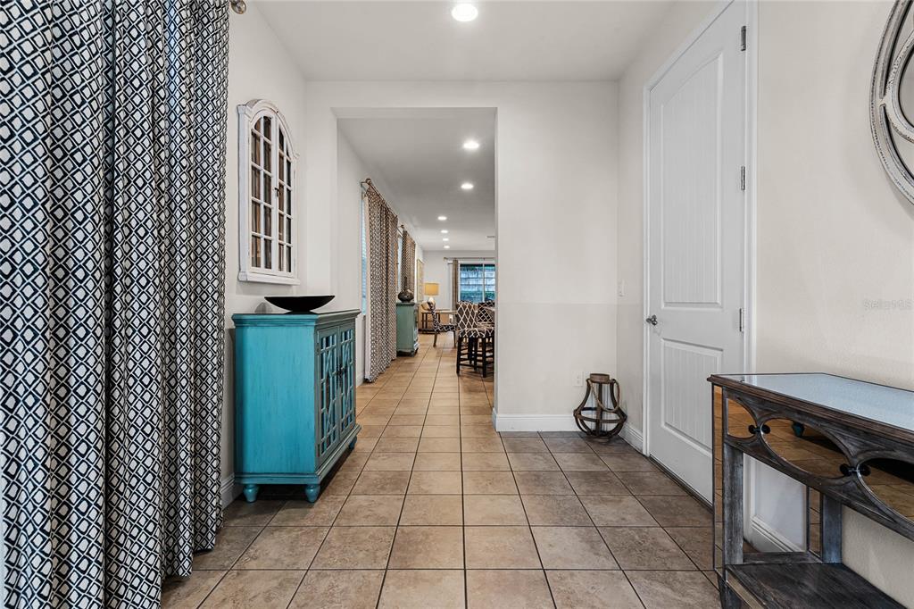 A tiled entryway leads into a dining area featuring a bright blue cabinet and curtains — 350 PENDANT COURT, KISSIMMEE, FL