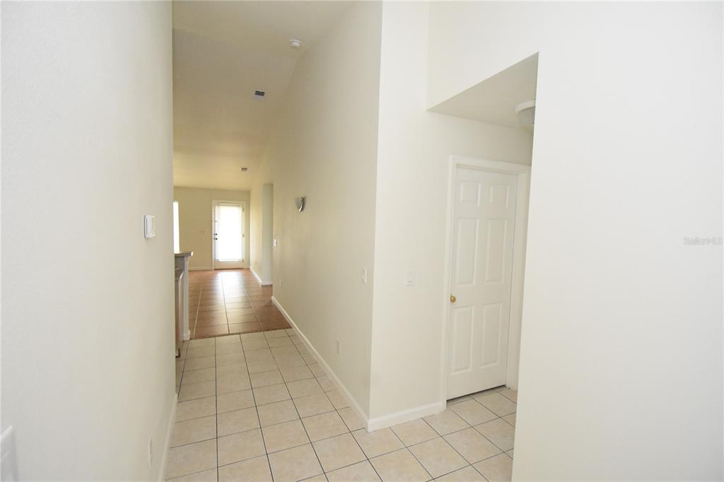 A tiled hallway leads to a doorway with a view of a bright living area — 30 ETON LANE, PALM COAST, FL