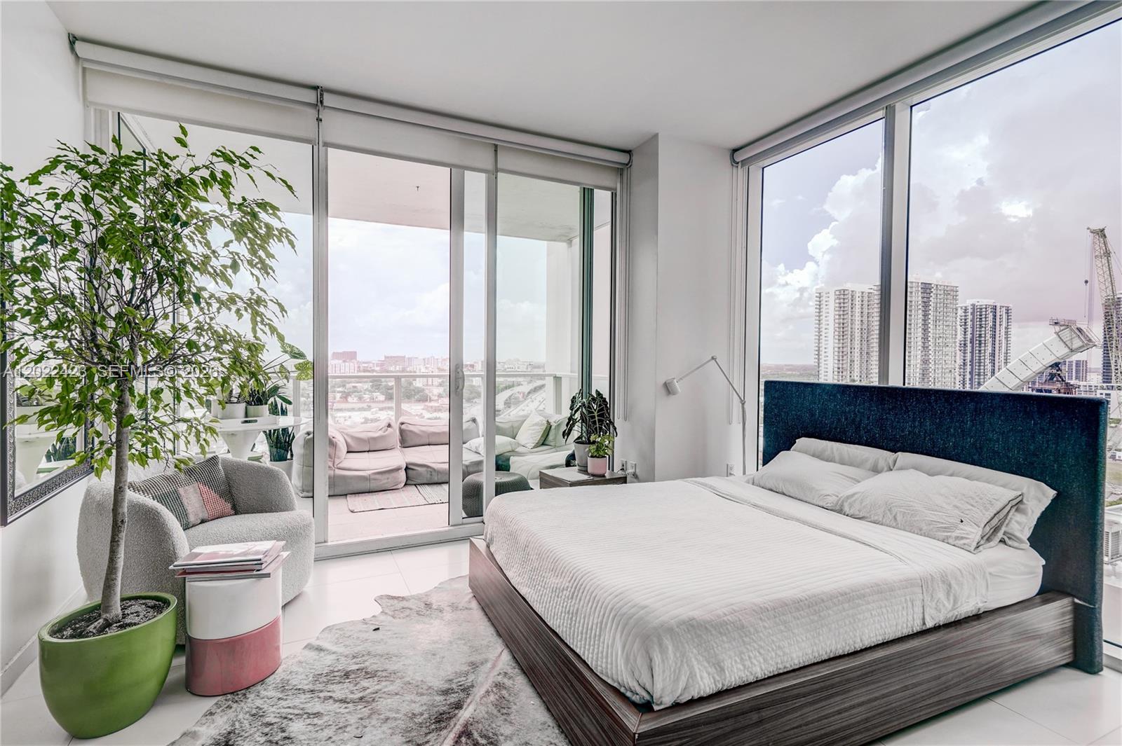 A modern bedroom with a platform bed, floor-to-ceiling windows, and a balcony with city views — 1040 Biscayne Blvd # 1606, Miami FL 33132, MIAMI, FL