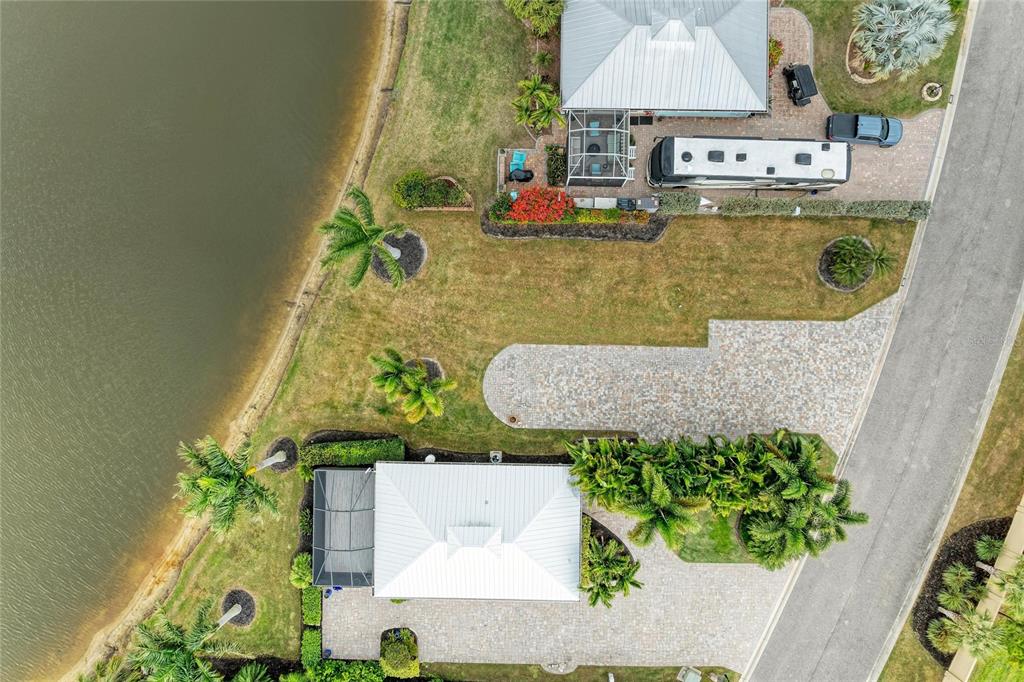 An aerial view shows two waterfront houses with paved driveways, palm trees, and a motorhome — 8801 SW SAND CRANE CIRCLE LOT 39, ARCADIA, FL