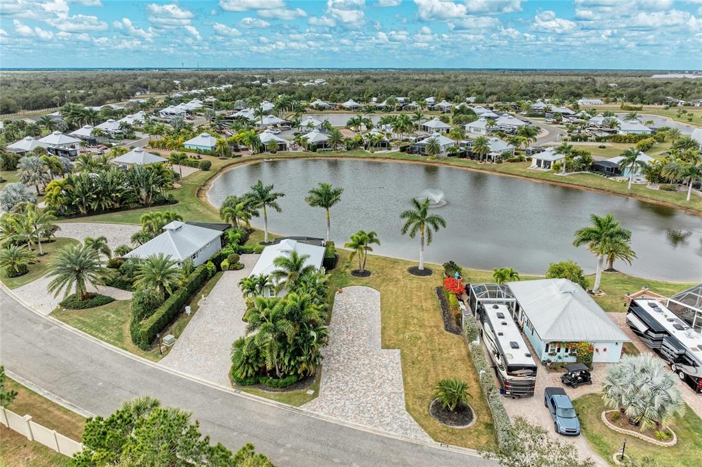An aerial view shows a residential neighborhood with houses, paved driveways, and a central pond — 8801 SW SAND CRANE CIRCLE LOT 39, ARCADIA, FL