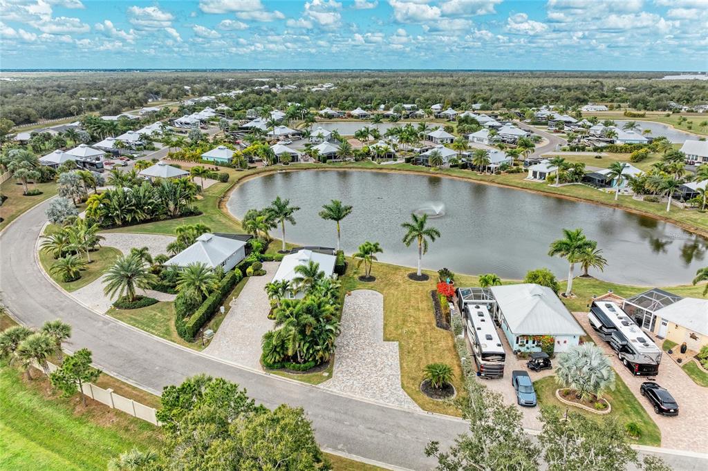 An aerial view shows a residential neighborhood with houses, driveways, palm trees, and a lake — 8801 SW SAND CRANE CIRCLE LOT 39, ARCADIA, FL