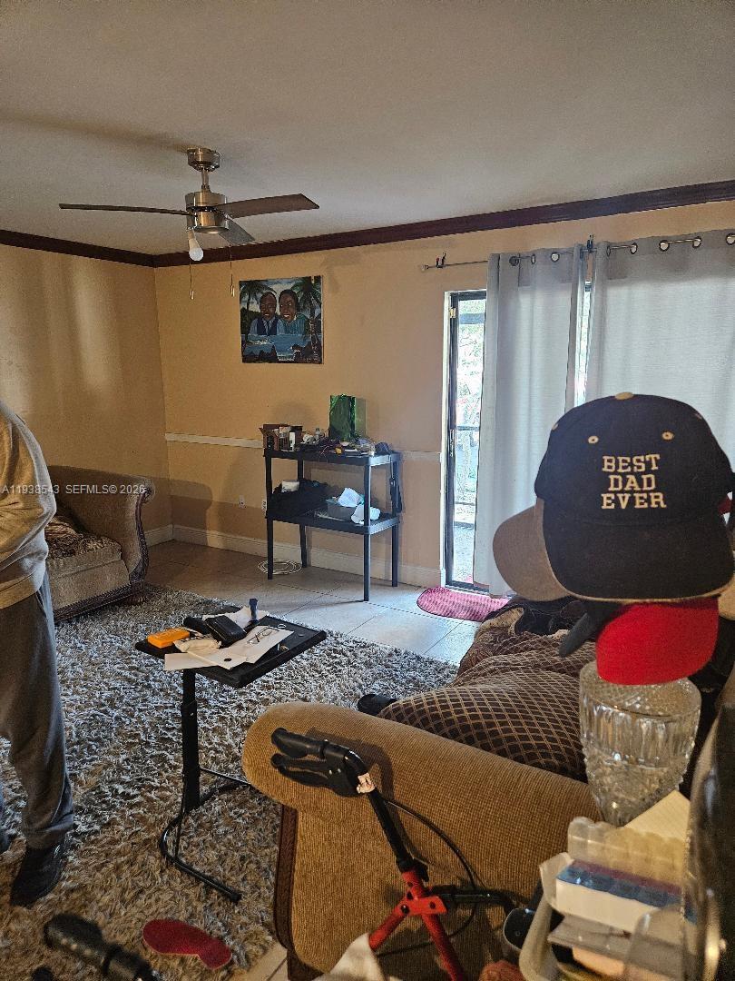 A living room features a ceiling fan, a patterned sofa, and a glass door — 18755 NW 62nd Ave # 101, Hialeah FL 33015, HIALEAH, FL