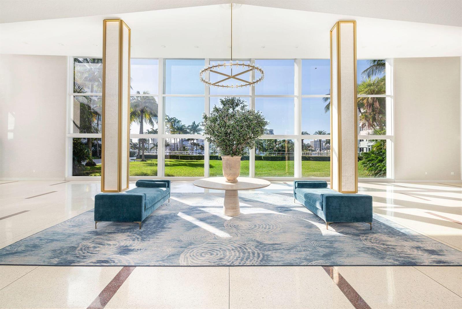 A bright lobby features a large area rug, two blue benches, and floor-to-ceiling windows — 44 Cocoanut Row # 227b, Palm Beach FL 33480, PALM BEACH, FL