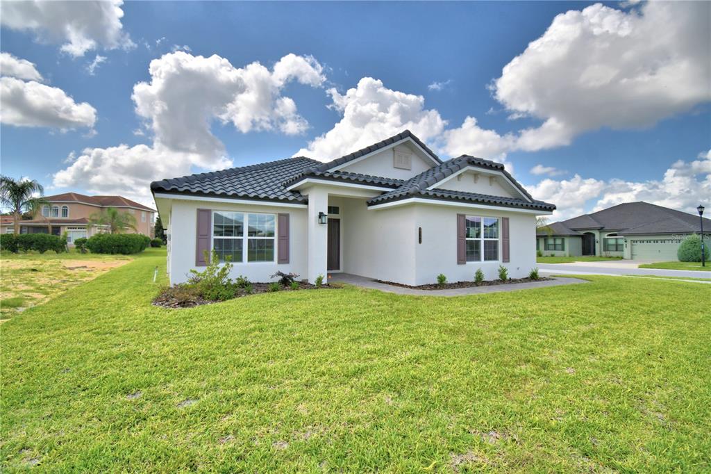 A single-story white stucco house with a dark tiled roof and brown shutters — 4502 GRANDVIEW GLEN DRIVE, AUBURNDALE, FL