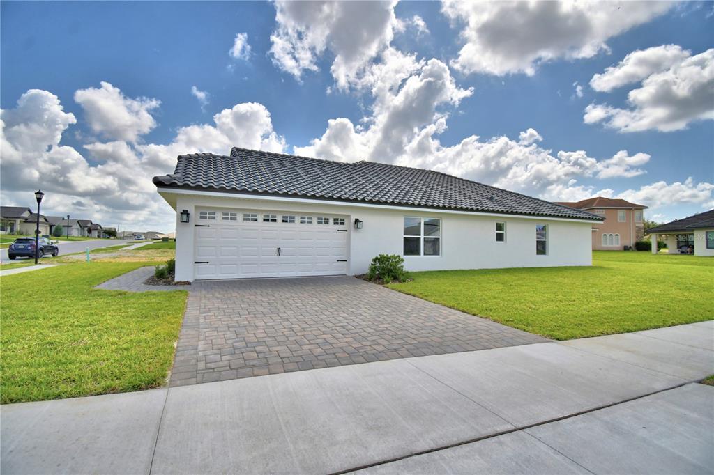 A white single-story house with a dark tiled roof and a paved driveway — 4502 GRANDVIEW GLEN DRIVE, AUBURNDALE, FL