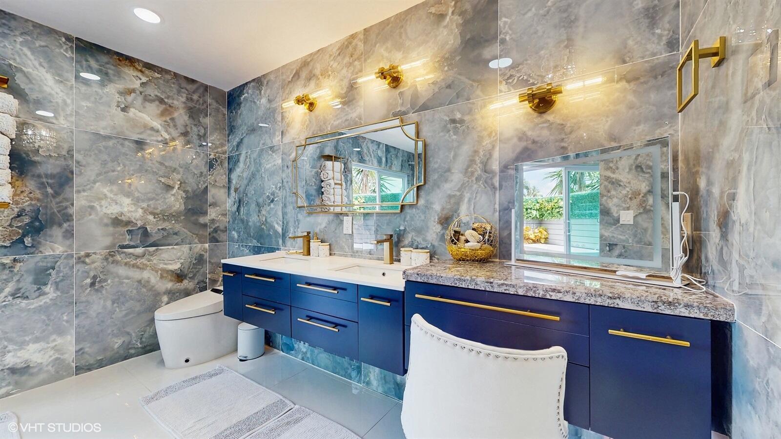 A bathroom features blue marble walls, a double vanity with gold hardware, and a makeup station — 11647 Anhinga Drive, Wellington FL 33414, WELLINGTON, FL