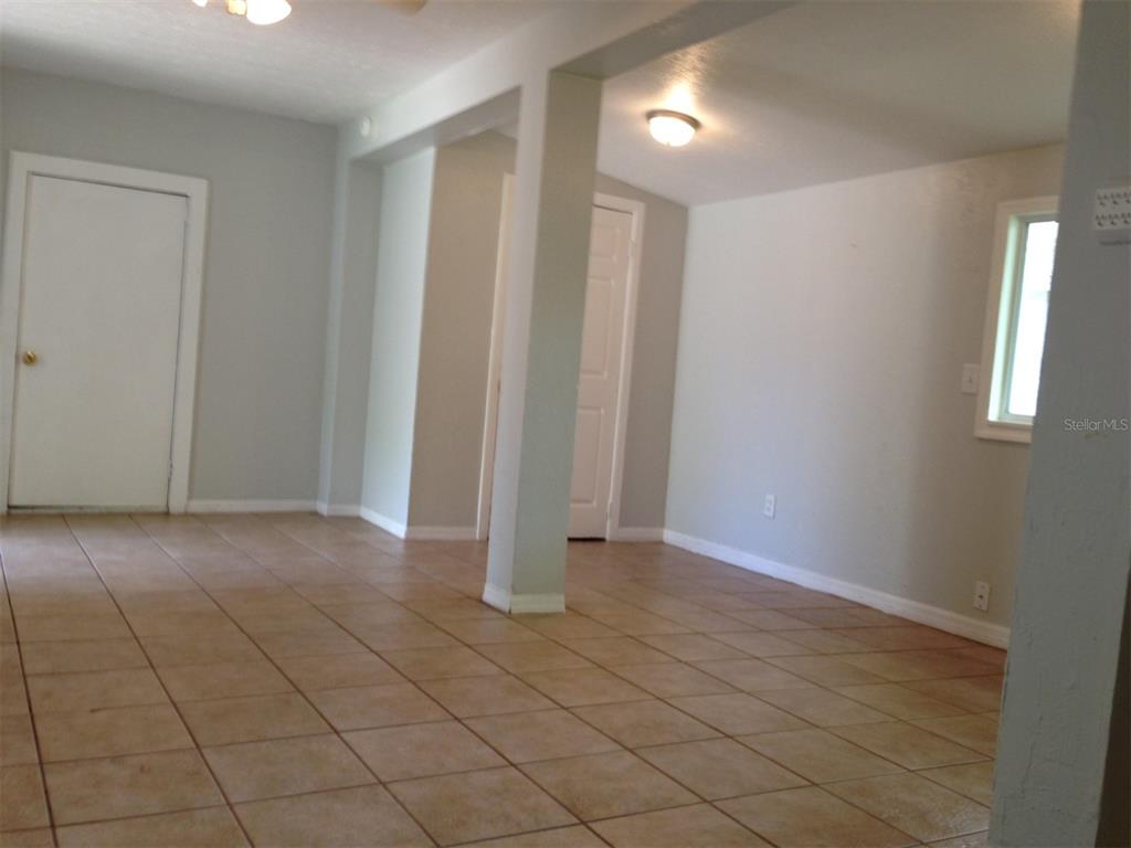 An interior room with light gray walls, tiled flooring, and a central support pillar — 1328 CLOVERLAWN AVENUE UNIT B, ORLANDO, FL