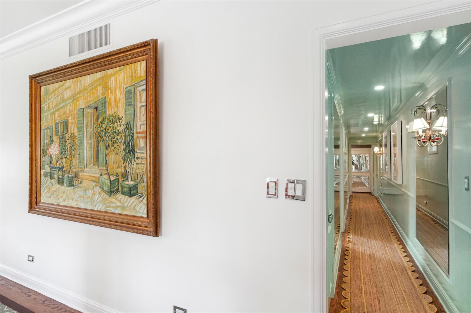 A white wall with a framed painting leads into a hallway with teal walls — 311 Cocoanut Row # 2010, Palm Beach FL 33480, PALM BEACH, FL