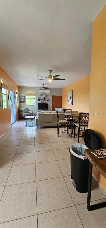 A living room with tile floors, a ceiling fan, and a dining area with chairs — Apt A-2 Ponciana Condo CARR 413 KM.4.1, RINCON, PR