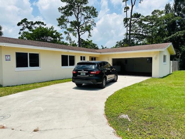 A single-story yellow house with a concrete driveway and an attached two-car garage — 3421 Helena Drive, Lake Worth FL 33461, LAKE WORTH, FL