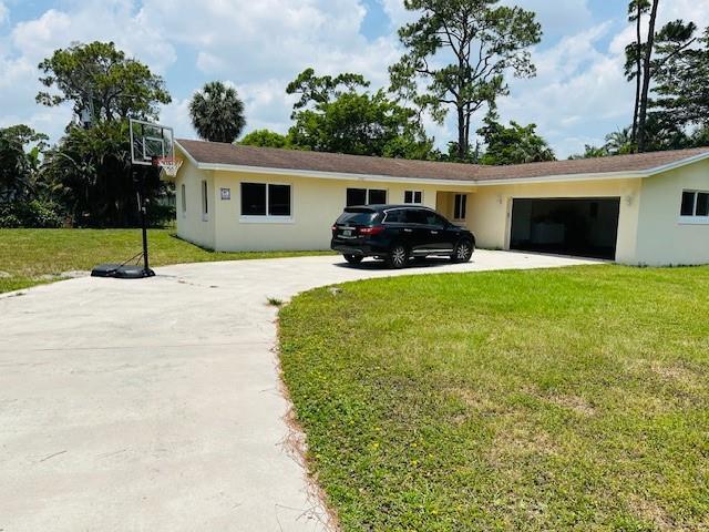 A single-story yellow house with a driveway, basketball hoop, and a black SUV parked outside — 3421 Helena Drive, Lake Worth FL 33461, LAKE WORTH, FL