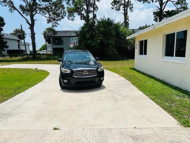A black Infiniti SUV is parked on a concrete driveway in front of a house — 3421 Helena Drive, Lake Worth FL 33461, LAKE WORTH, FL