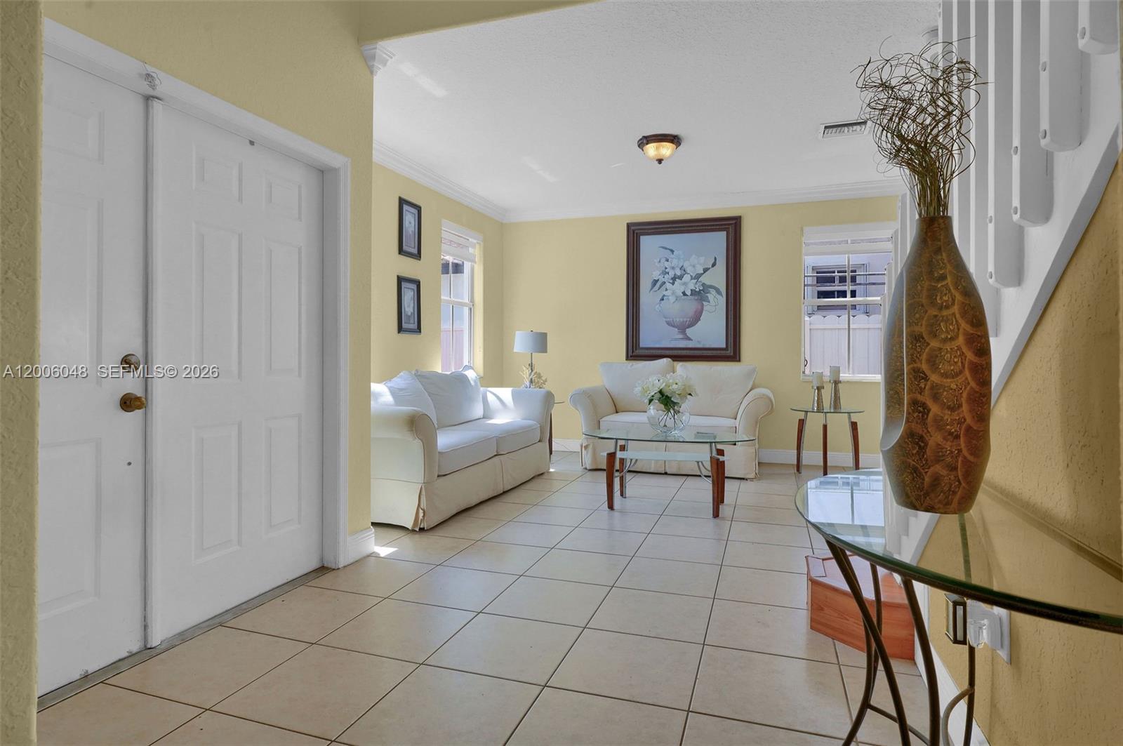 A living room features light yellow walls, tile flooring, and two white sofas — 6114 SW 158th Pass, Miami FL 33193, MIAMI, FL