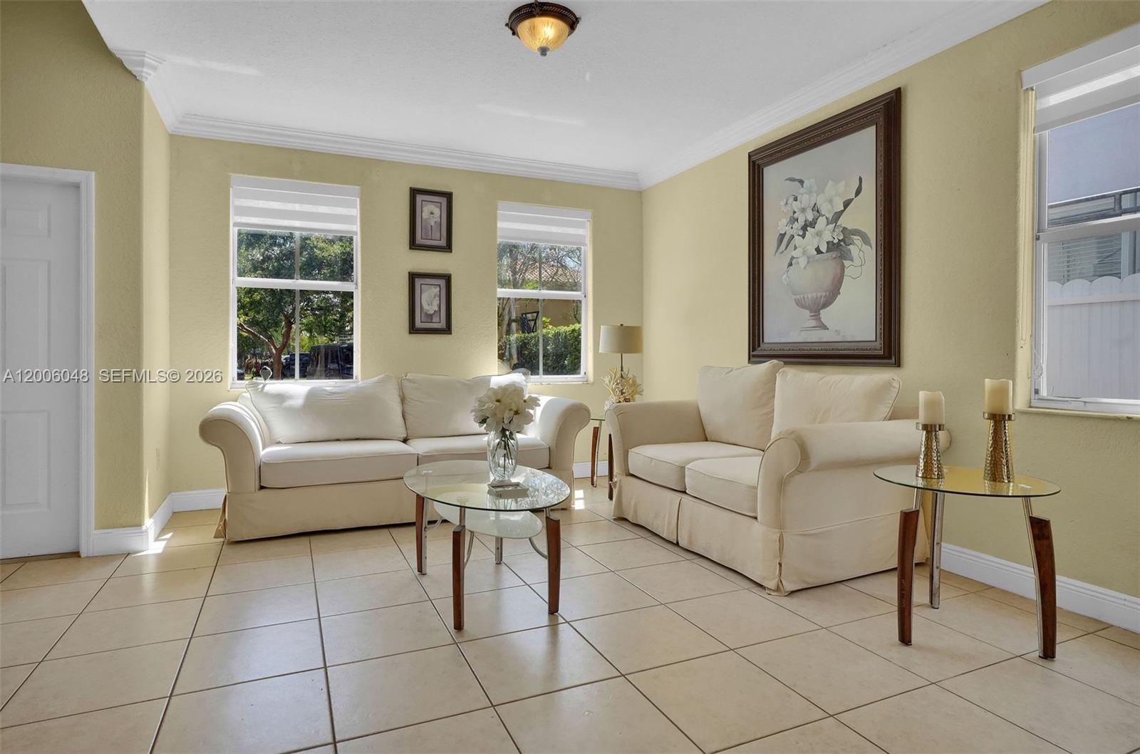 A living room features light-colored sofas, a glass coffee table, and tile flooring — 6114 SW 158th Pass, Miami FL 33193, MIAMI, FL