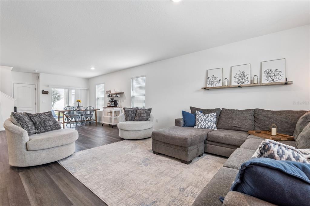 A living room features a gray sectional sofa, two round chairs, and a dining area — 5368 HAYLOFT DRIVE, APOPKA, FL