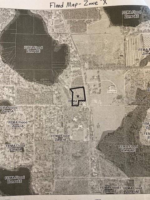 This is a flood zone map showing a property outlined in black with a star — 18040 GUNN HIGHWAY, ODESSA, FL