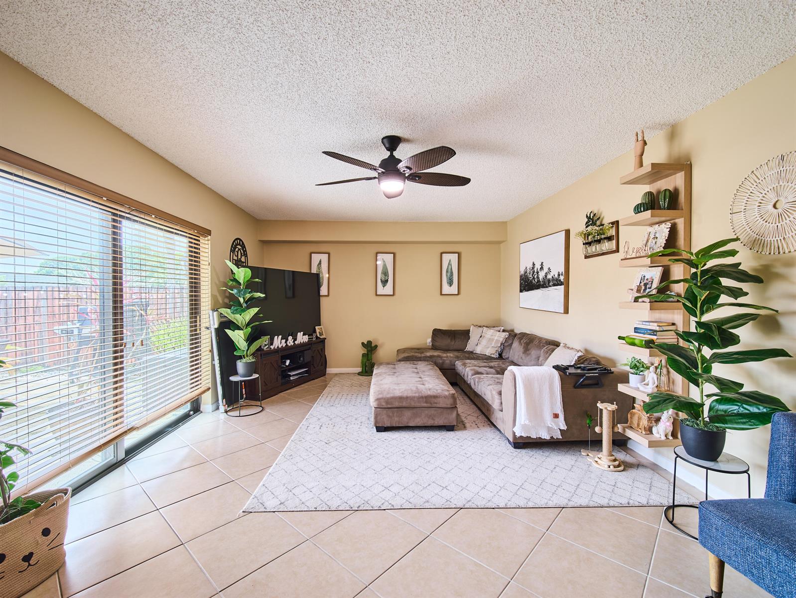 A living room features a brown sectional sofa, a television, and a tall wooden shelving unit — 3113 31st Way, West Palm Beach FL 33407, WEST PALM BEACH, FL