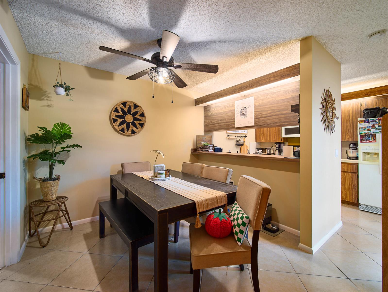 A dining area features a dark wood table, chairs, a bench, and a ceiling fan — 3113 31st Way, West Palm Beach FL 33407, WEST PALM BEACH, FL