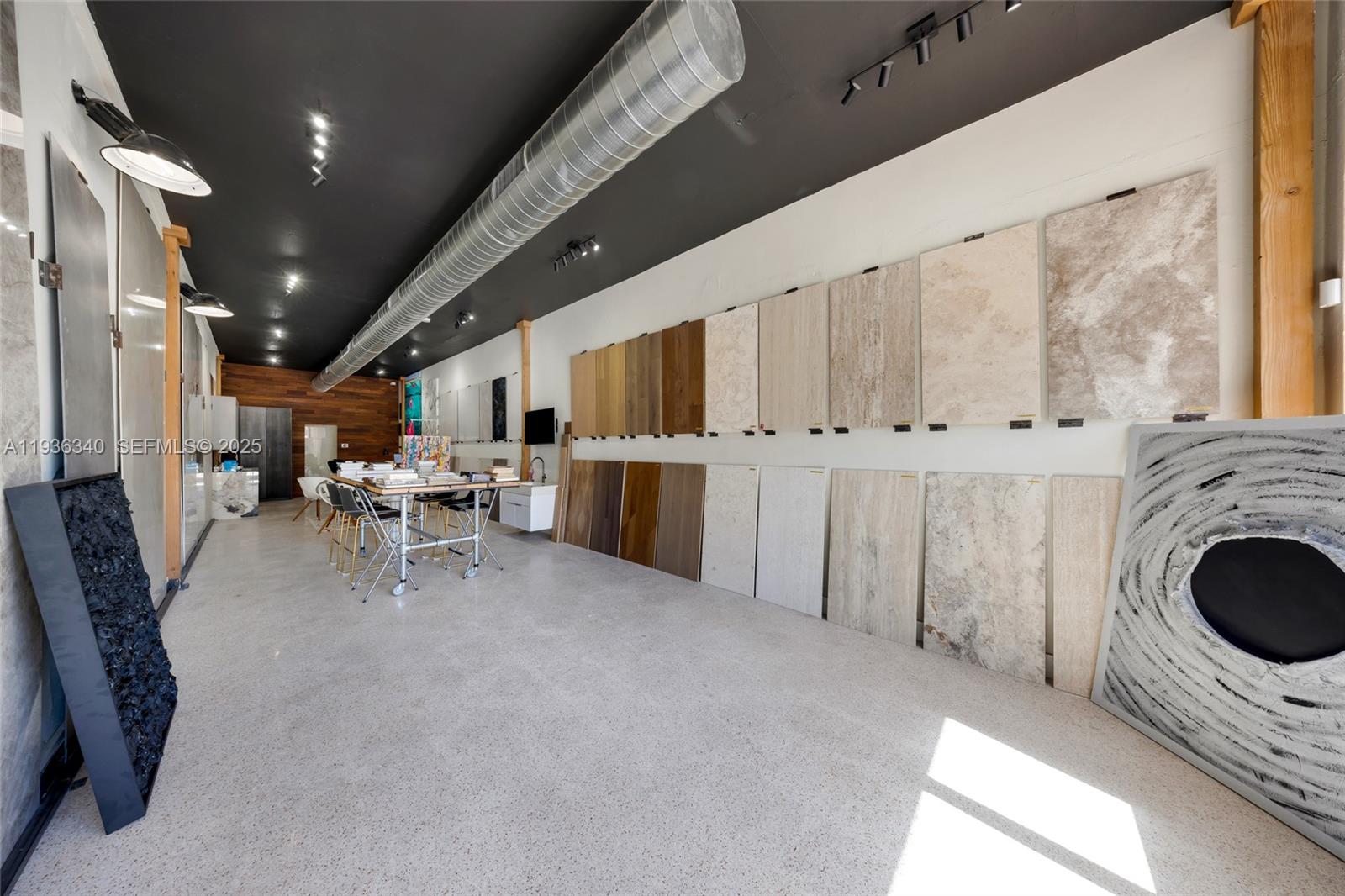 A showroom features large tile and wood flooring samples displayed on a white wall — 1975 71st St, Miami Beach FL 33141, MIAMI BEACH, FL