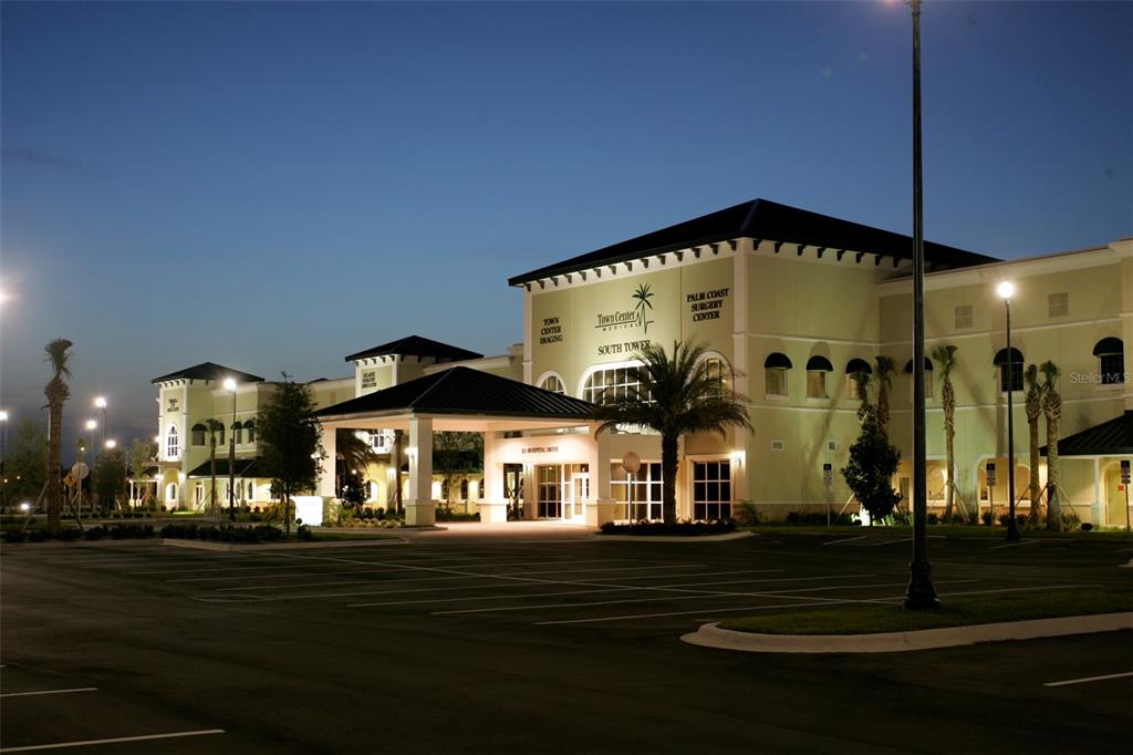 A multi-story medical office building with a covered entrance and parking lot at dusk — 21 HOSPITAL DRIVE UNIT 120, PALM COAST, FL