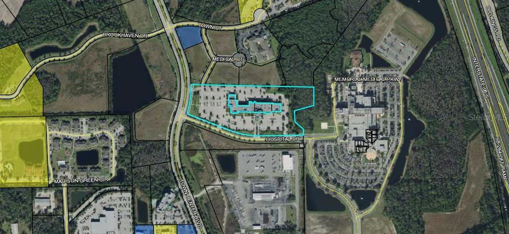This aerial map shows a commercial property outlined in blue near a hospital and highway — 21 HOSPITAL DRIVE UNIT 120, PALM COAST, FL