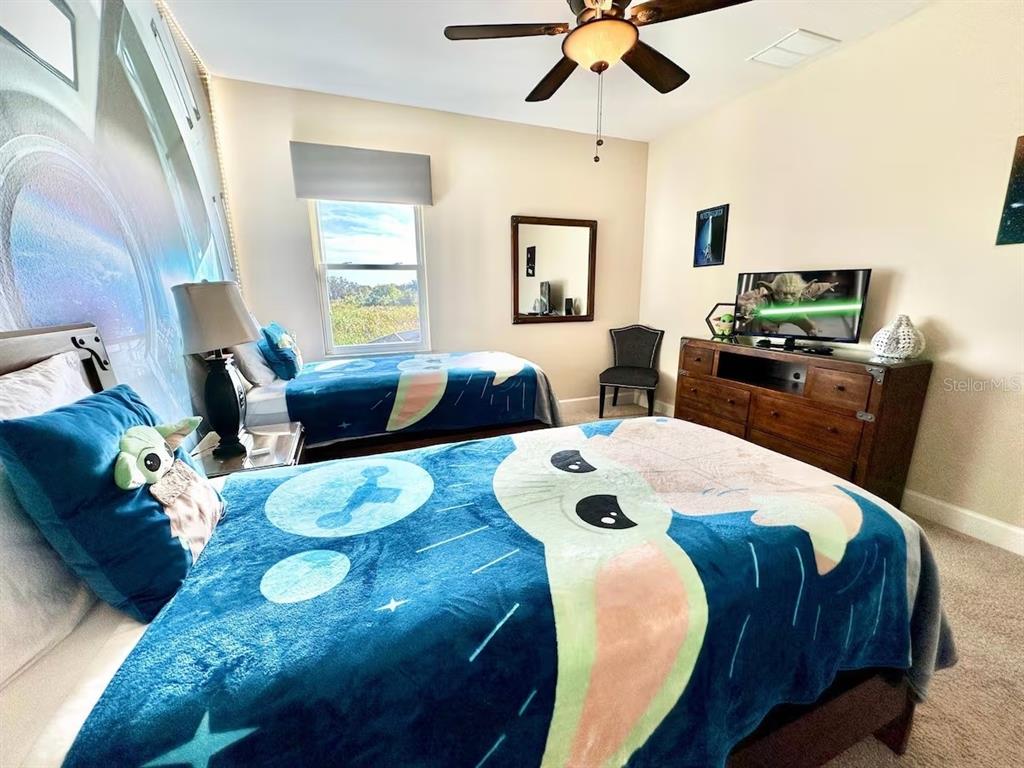 A bedroom features two twin beds with Star Wars-themed bedding and a wooden dresser — 4353 ACORN COURT, DAVENPORT, FL