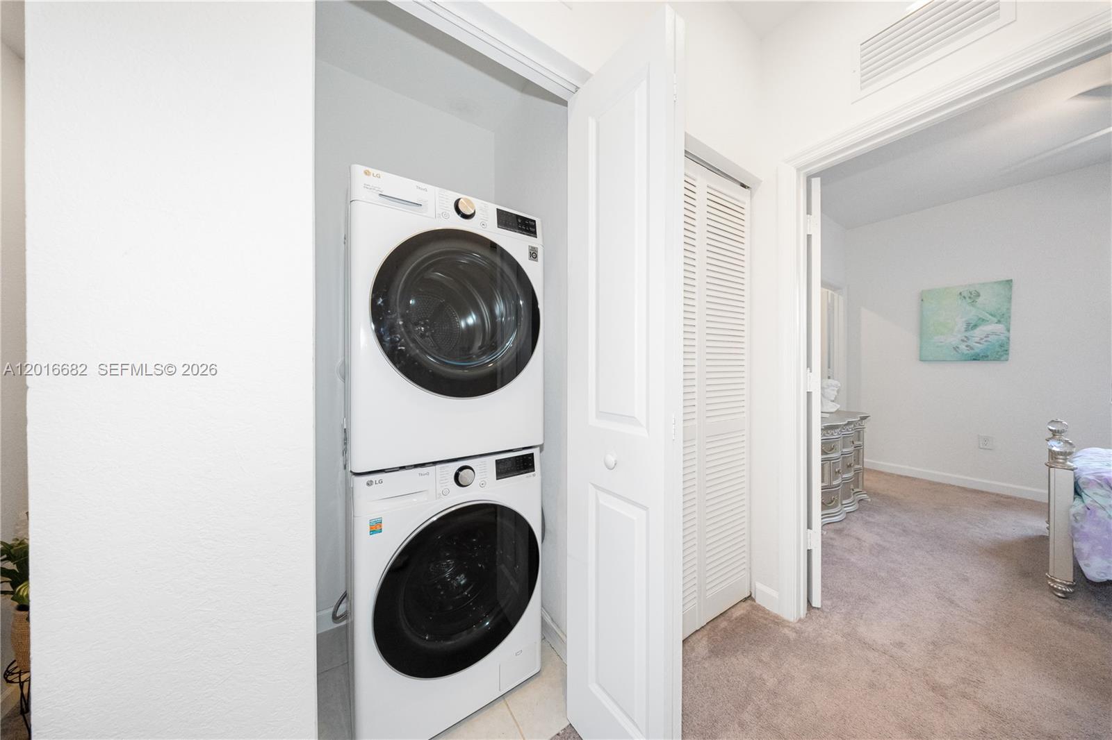 A stacked LG washer and dryer unit is located in a closet next to a bedroom — 18236 SW 148th Rd, Miami FL 33187, MIAMI, FL