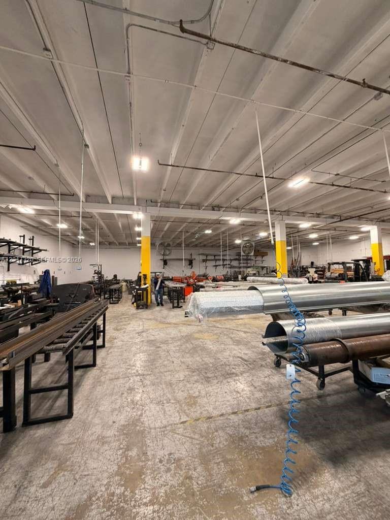 A spacious industrial warehouse interior features concrete floors, exposed ceiling beams, and metal fabrication equipment — 7207-7217 NW 32nd ST, Miami FL 33122, MIAMI, FL