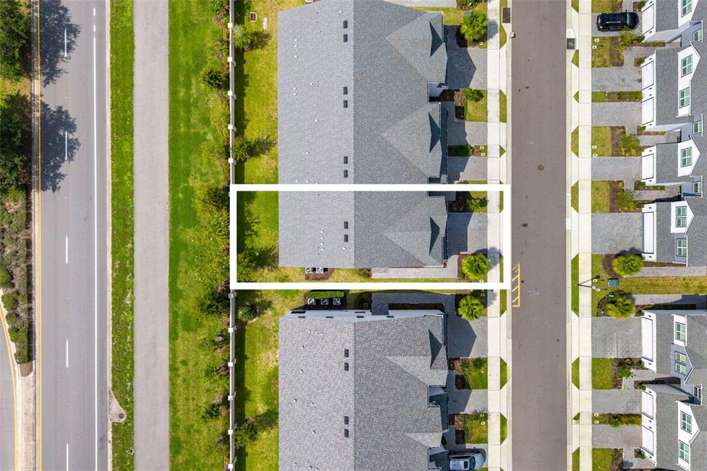 A side view of a white multi-story townhouse with a paved driveway and walkway — 1445 BROOKDALE COURT, OVIEDO, FL