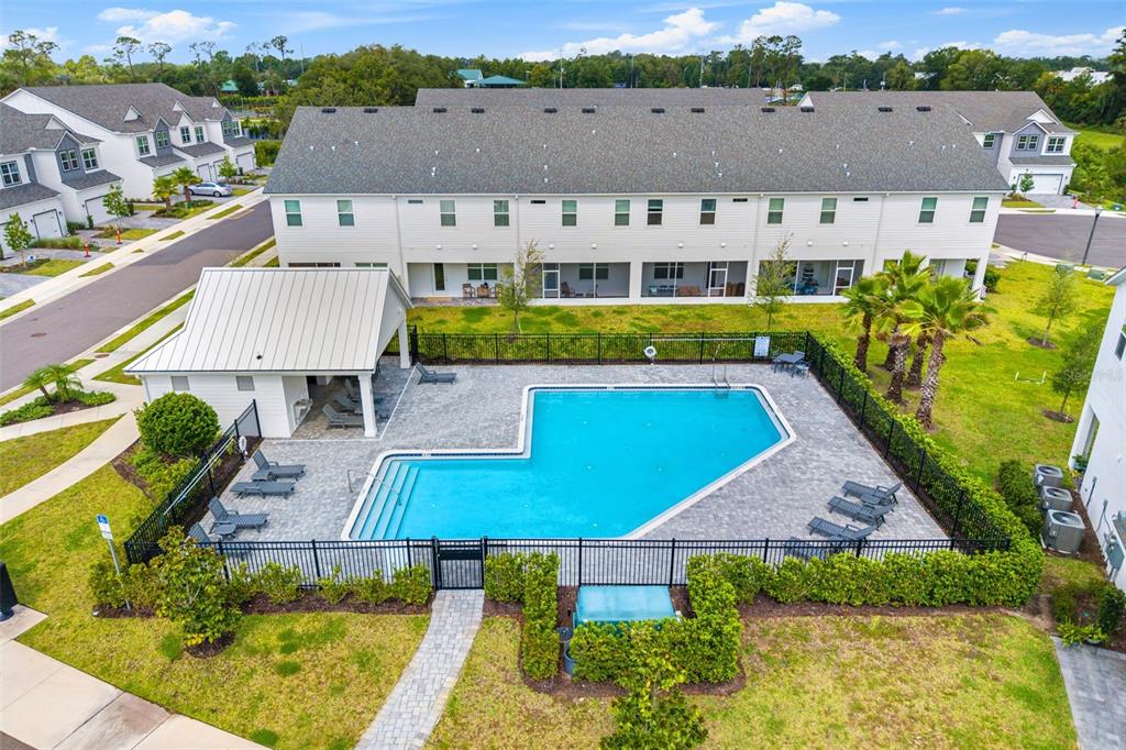 A paved walkway leads to the front entrance of a white house with a dark door — 1445 BROOKDALE COURT, OVIEDO, FL
