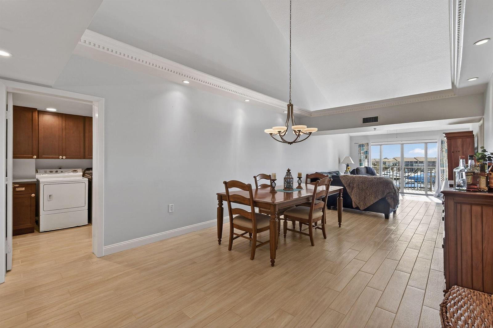 A dining area with a wooden table and chairs sits beneath a vaulted ceiling — 701 Seafarer Circle # 504, Jupiter FL 33477, JUPITER, FL