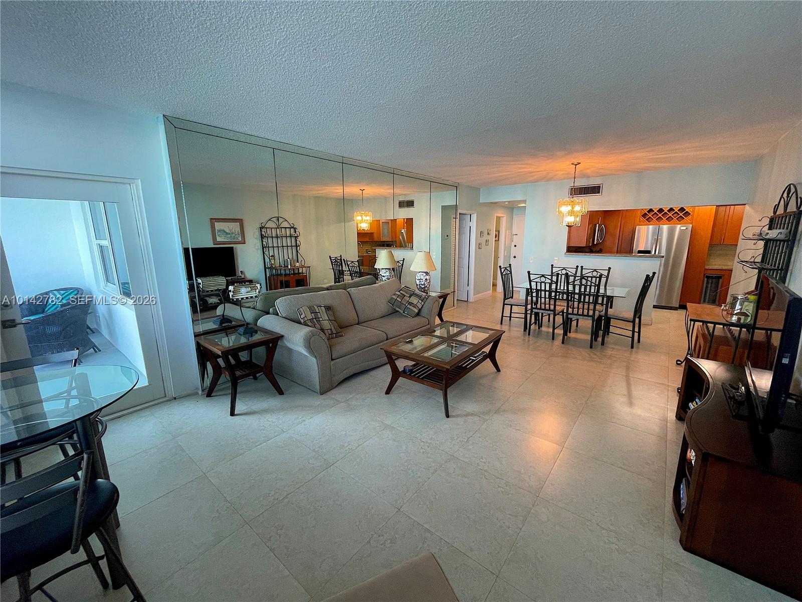 A living and dining area features tile floors, a mirrored wall, and wooden furniture — 3505 S Ocean Dr # 1415, Hollywood FL 33019, HOLLYWOOD, FL