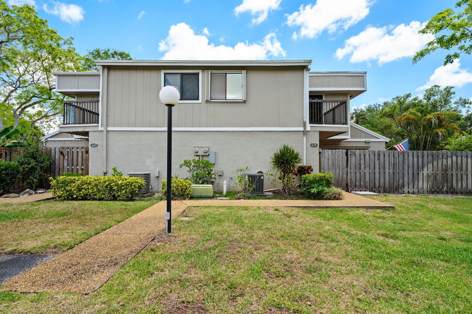 A two-story duplex building features beige siding, balconies, and a shared front lawn — 620 Commodore Drive, Plantation FL 33325, PLANTATION, FL
