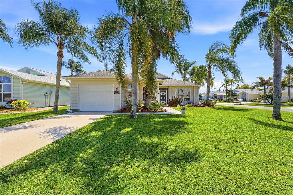 A single-story house with a white garage and palm trees on a sunny day — 5930 FOXTAIL WAY, FORT PIERCE, FL